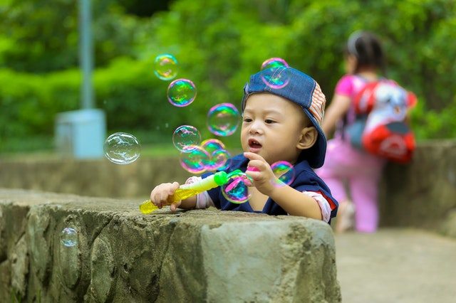 Son blowing bubbles