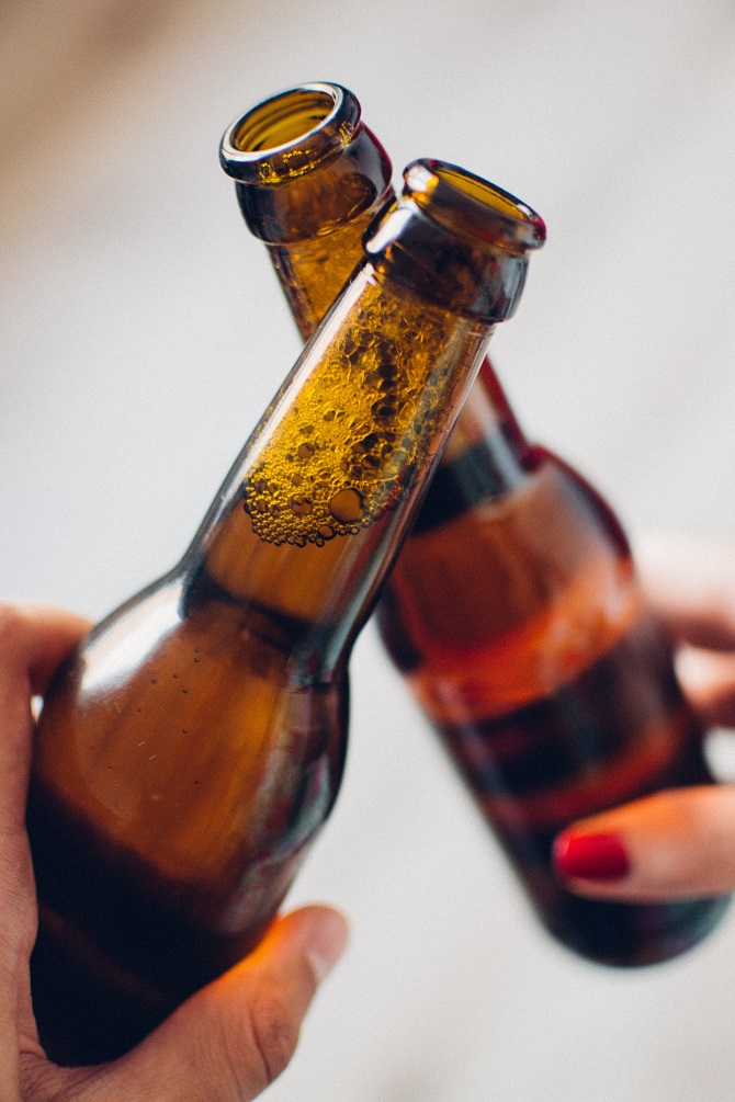 cheers or toasting with beer bottles
