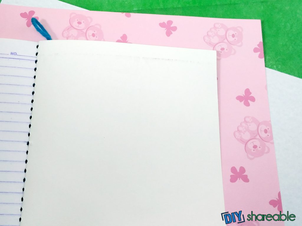 preparing wrapping paper for DIY notebook leaving excess to fold over
